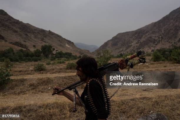 Member of the Afghan Local Police walks past the area where the United States dropped the GBU-43/B Massive Ordnance Air Blast, nicknamed the "Mother...