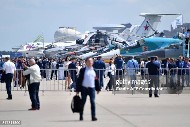 Visitors look at the exhibited airplanes on July 18, 2017 during the opening day of the annual air show MAKS 2017 in Zhukovsky, some 40 km outside...