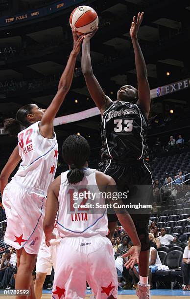 Sophia Young of the San Antonio Silver Stars puts up a shot under pressure against Stacey Lovelace and Ivory Latta of the Atlanta Dream during the...
