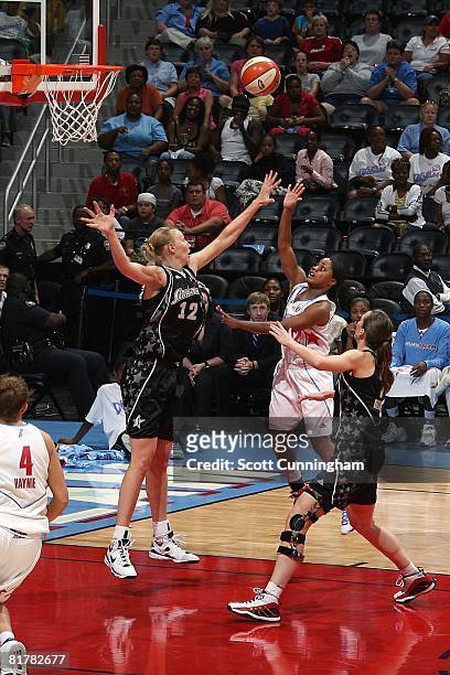 Ivory Latta of the Atlanta Dream puts up a shot under pressure against Ann Wauters and Erin Buescher of the San Antonio Silver Stars during the WNBA...