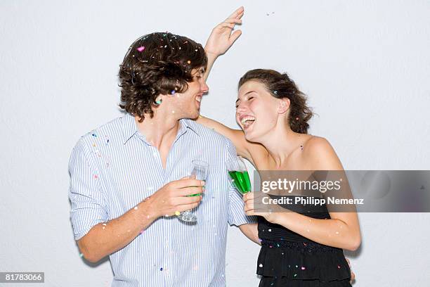 young couple laughing at party,with green drinks, confetti in hair - philipp nemenz bildbanksfoton och bilder