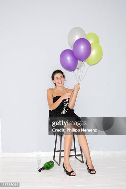 girl in black dress, sitting with ballons, bottle on the floor - philipp nemenz bildbanksfoton och bilder