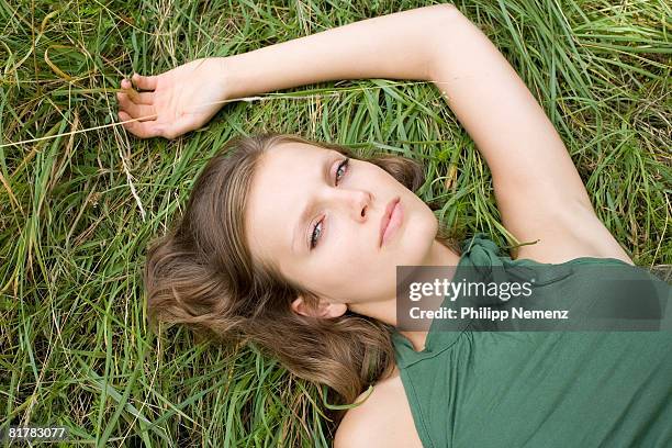 portrait of girl in green top, horizontal on lawn - philipp nemenz bildbanksfoton och bilder