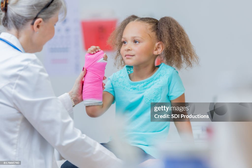 Junger Patient hält gebrochenen arm