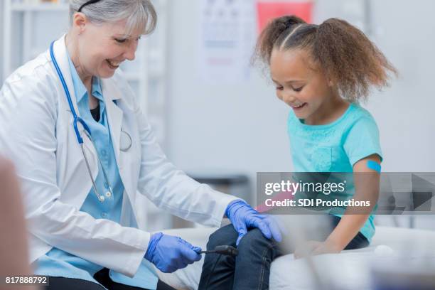 confident pediatrician checks young girl's reflexes - reflex hammer stock pictures, royalty-free photos & images