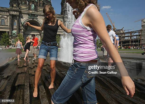 Young people cool off at a water fountain next to the Dom cathedral as temperatures reached 27 degrees Celsius on July 1, 2008 in Berlin, Germany....