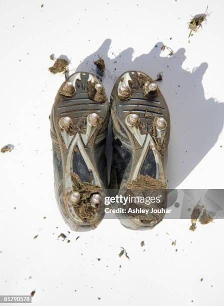 pair of muddy football boots - studs showing - studded stock pictures, royalty-free photos & images