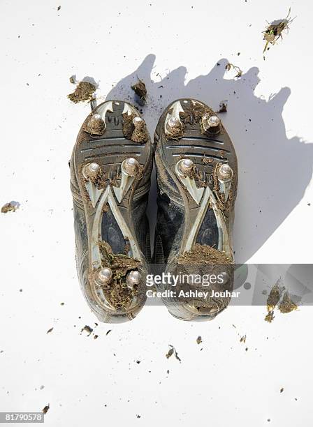 pair of muddy football boots - studs showing - 釘鞋 個照片及圖片檔