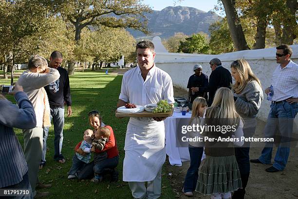 Waiter carries a grape and cheese platter during a birthday party on May 26, 2007 at Groot Constantia, South Africa's oldest vine yard outside Cape...