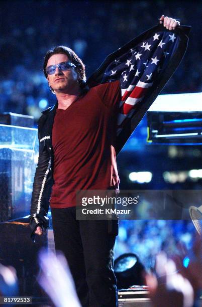 Bono, lead singer of U2, displays American flag lining in his jacket after singing "Where The Streets Have No Name", during the halftime show of...