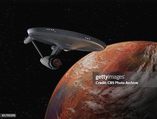 The Starship Enterprise flies over an orange planet in 'The Man Trap,' the premiere episode of 'Star Trek,' which aired on September 8, 1966.