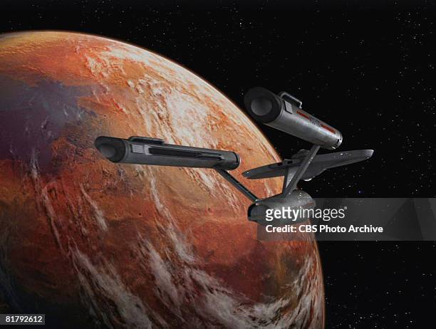 The Starship Enterprise flies over an orange planet in 'The Man Trap,' the premiere episode of 'Star Trek,' which aired on September 8, 1966.