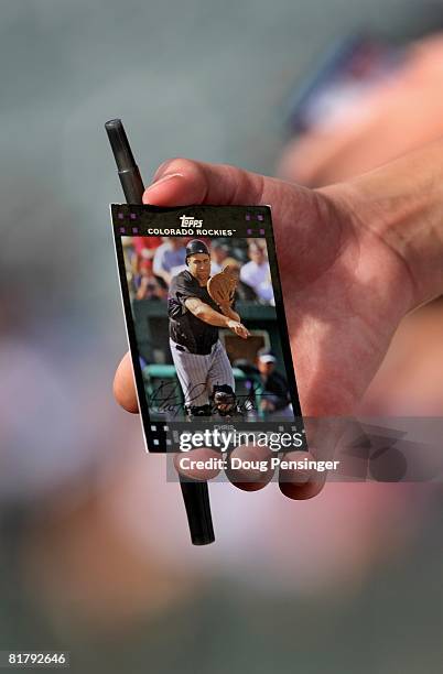 Fan holds a trading card featuring Chris Iannetta of the Colorado Rockies as he pursues autographs prior to the Rockies facing the San Diego Padres...