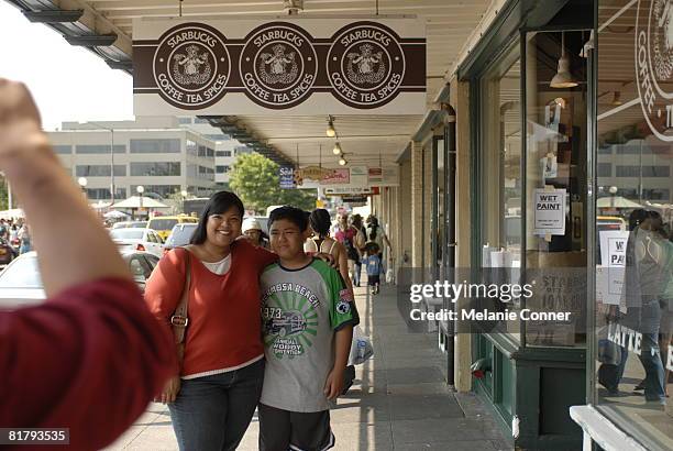 Tina, left, and Kindred Barlolong pose outside of the flagship Starbucks store at Pike Place July 1, 2008 in Seattle, Washington. Starbucks Corp....