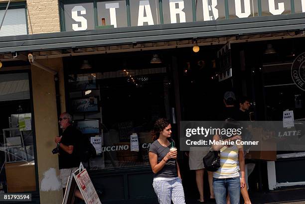 Pedestrians walk by the flagship Starbucks store at Pike Place July 1, 2008 in Seattle, Washington. Starbucks Corp. Announced that it plans to close...