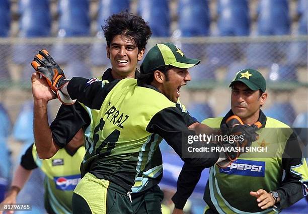 Pakistan cricketers Sarfraz Ahmed and Younus Khan congratulate teammate Abdur Rauf for the wicket of Indian cricketer Suresh Raina during the Super...