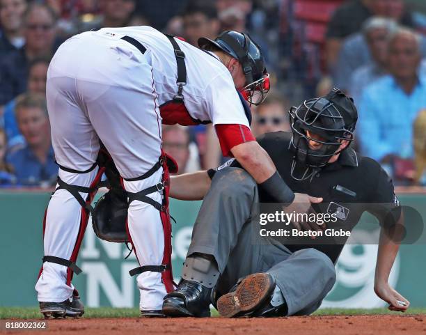 Red Six catcher Christian Vazquez comes to the aid of home plate umpire Chris Segal after he was hit in the head by the bat of the Blue Jays' Josh...