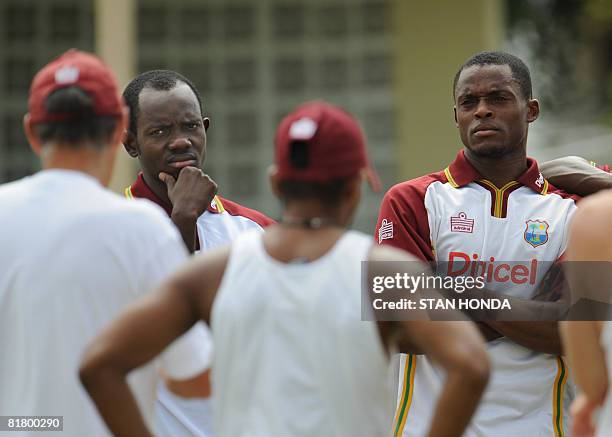 West Indies cricketers Nikita Miller and Daren Powell listen to coach John Dyson during a practice session on July 2, 2008 at Warner Park in...