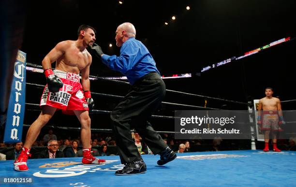 Robert Guerrero, left, is administered a ten count by referee Ron Lipton, after being knocked down for the third time by Omar Figueroa Jr., who waits...