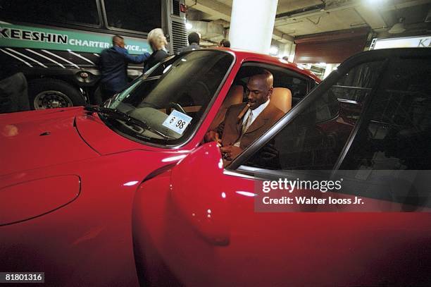 Basketball: Casual portrait of Chicago Bulls Michael Jordan sitting in Porsche with cigar after game, Chicago, IL 2/1/1998