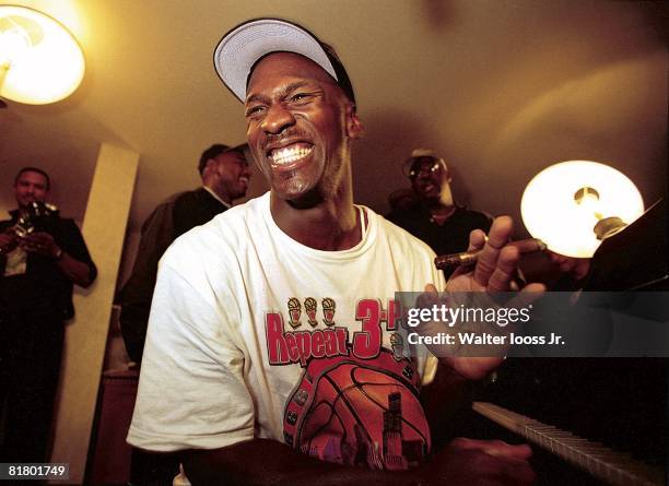 Basketball: NBA Finals, Closeup of Chicago Bulls Michael Jordan victorious playing piano and smoking cigar in hotel after winning Game 6 and...