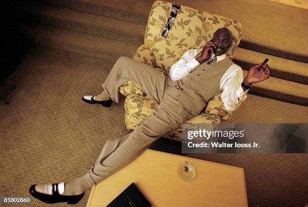 Basketball: Casual portrait of Chicago Bulls Michael Jordan talking on cellular phone and smoking cigar in hotel room, Orlando, FL 3/25/1998