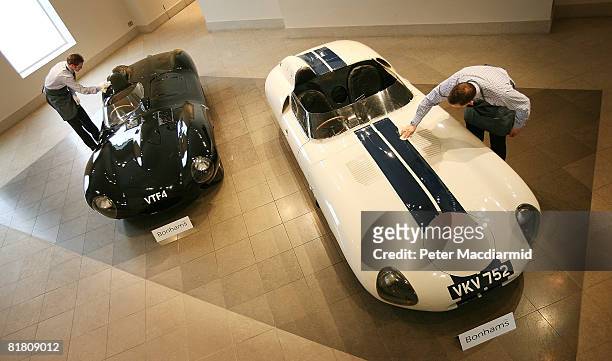 Bonhams auctioneers prepare two valuable Jaguar cars for sale on July 3, 2008 in London. The black Jaguar D-Type was the very first to roll off the...
