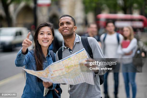 happy students sightseeing in london and holding a map - tourist map stock pictures, royalty-free photos & images