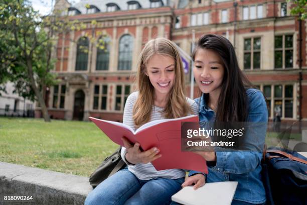 gelukkig vrouwelijke studenten studeren buiten - london england stockfoto's en -beelden