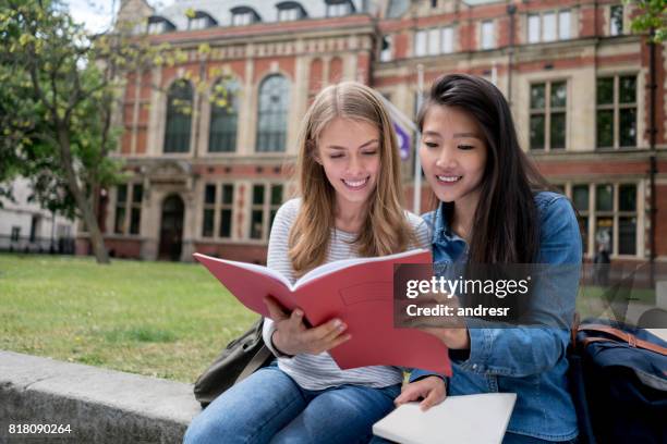 happy female students studying outdoors - chinese students stock pictures, royalty-free photos & images
