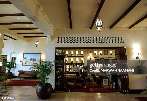 Guests take a look at souvniers at the gift shop in the lobby of al-Maha resort and nature reserve, some 100 kms south of the Gulf emirate of Dubai,...