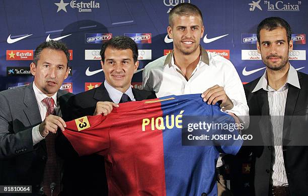 Barcelona's technical secretary Txiki Begiristain, President Joan Laporta, new signing Catalan Gerard Pique and coach Pep Guardiola pose on July 3,...