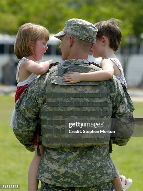 Carrying his daughters Molly and Emily Sgt. Kenneth Messer walks to her car after a homecoming ceremony for 270 soldiers with the U.S. Army's 2nd...