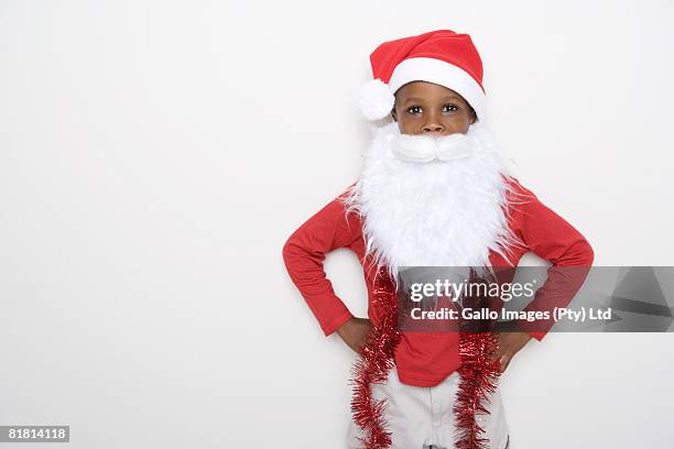 boy dressed up like father christmas with a hat on his head and a fake father christmas beard - santa hat and beard stock pictures, royalty-free photos & images