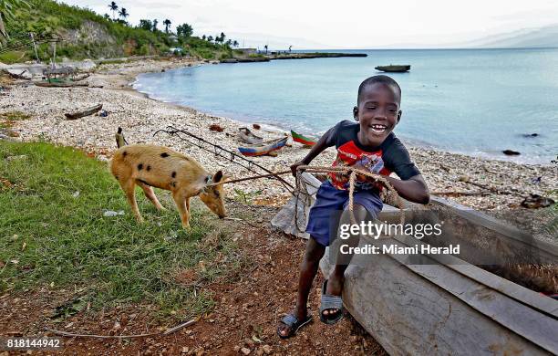 Young boy keeps his pig nearby along the shore in Port Salut, Haiti in late June, nearly nine months after Hurricane Matthew struck the area.