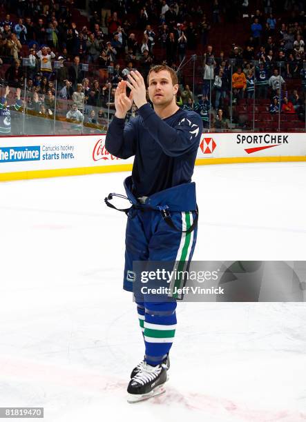 Markus Naslund applauds for the fans at the end of his last game as a Vancouver Canuck during their game against the Calgary Flames at General Motors...