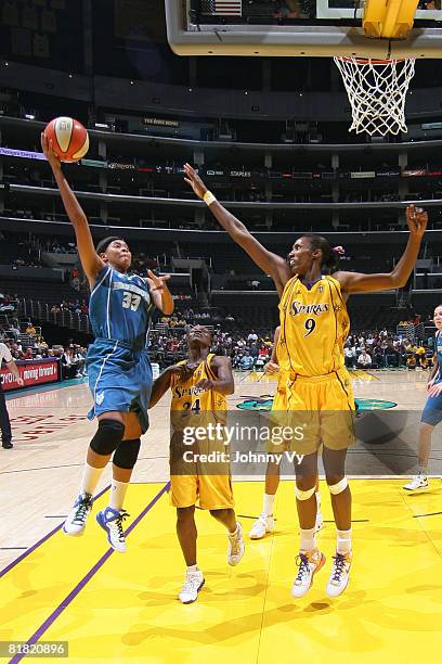 Seimone Augustus of the Minnesota Lynx goes up for a shot against the defense of Lisa Leslie of the Los Angeles Sparks during their game on July 3,...