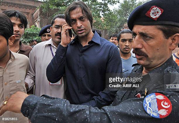 Pakistani policeman clears the way for cricketer Shoaib Akhtar after he filed an appeal at a court in Lahore on July 4, 2008. A Pakistani court on...