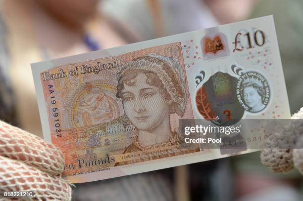 People in period costume pose with one of the Bank of England's new ten pound notes, featuring British author Jane Austen, during its unveiling at...