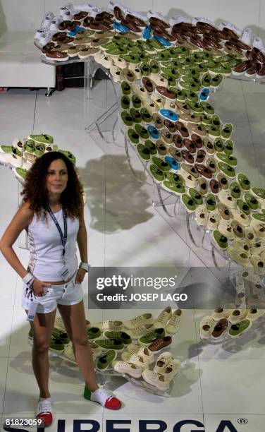 Stand keeper waits in front of a giant Italy map made with shoes during the "Bread & Butter" fashion tradeshow on July 4, 2008 in Barcelona, closing...