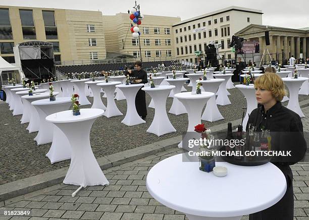 Waitresses bring drinks to tables installed in front of the new US embassy in Berlin on July 4 on the day the building will officially be inaugurated...