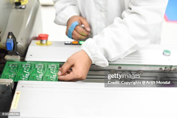 electronic factory worker holding pcb with esd band also called electrostatic discharge band - electrostatic discharge stock pictures, royalty-free photos & images