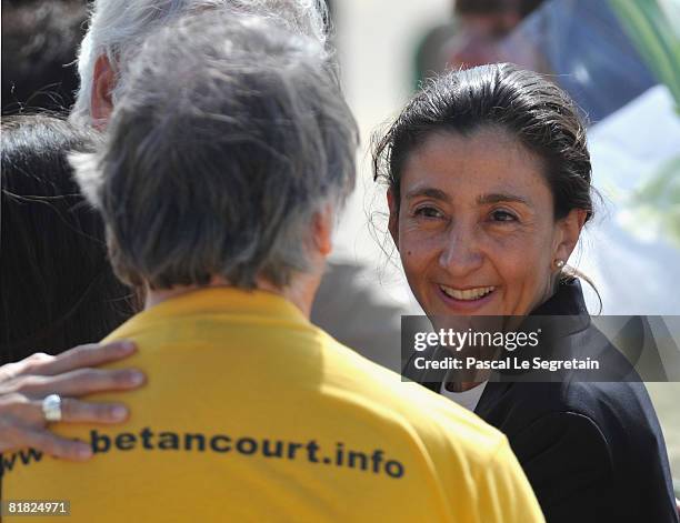 Ingrid Betancourt smiles at an unidentified member of her support committee during the arrival ceremony at military base of Villacoublay on July 4,...