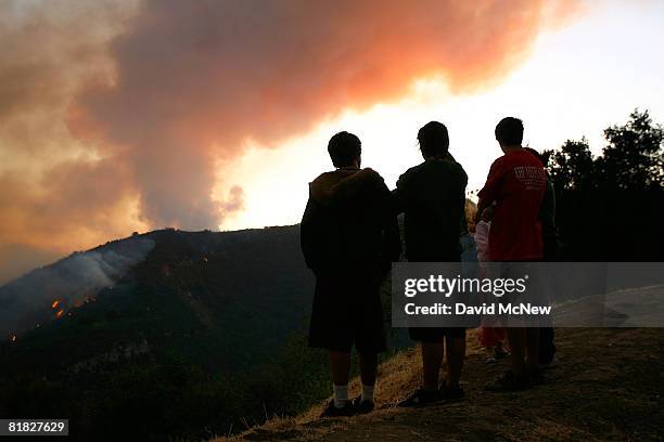 Residents whose back-country homes were destroyed by a massive fire in 1990, and whose homes are again in danger of being consumed, watch the...