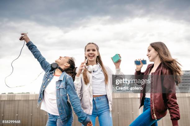 trois adolescentes prenant des vivats à l’extérieur - sing outside photos et images de collection