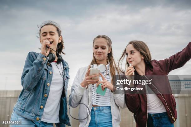 three teenage girls fooling around outdoors - saga perform in berlin stock pictures, royalty-free photos & images