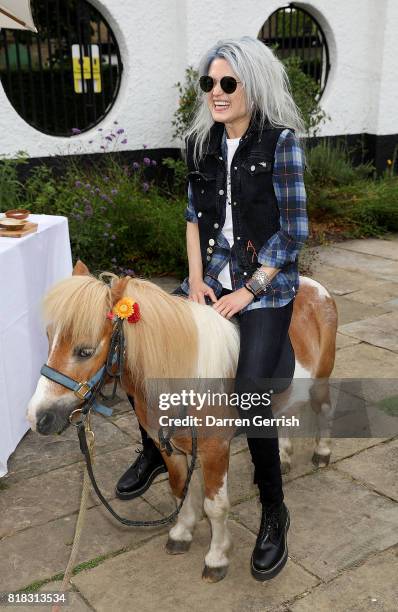 Alison Mosshart rides Freddie the Shetland pony at the J Brand x Bella Freud garden tea party on July 18, 2017 in London, England.