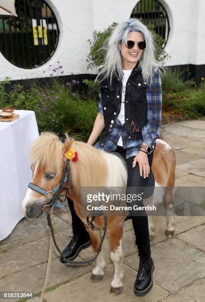 Alison Mosshart rides Freddie the Shetland pony at the J Brand x Bella Freud garden tea party on July 18, 2017 in London, England.