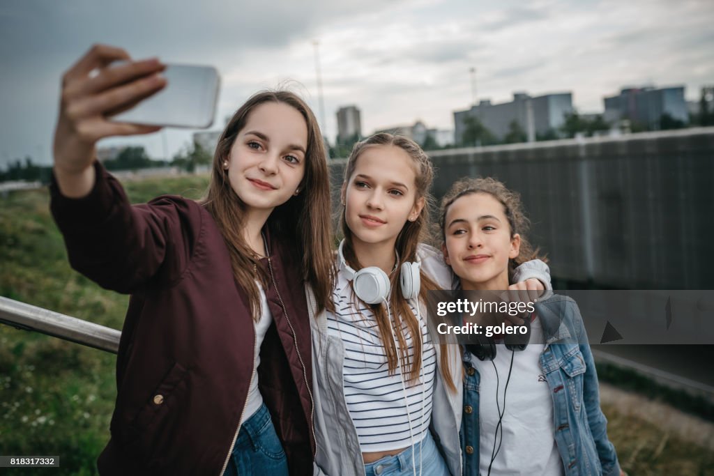 Drei Mädchen im Teenageralter unter Selfie im freien