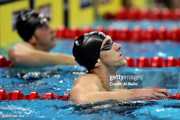 Winner Michael Phelps, right, and second place finisher Ian Crocker, left, look at the scoreboard after the final of the 100 meter butterfly during...